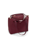 Wine TUMI handbag with gold accents on a white background