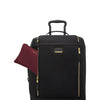 Black TUMI suitcase with gold accents and a matching maroon pouch on a white background