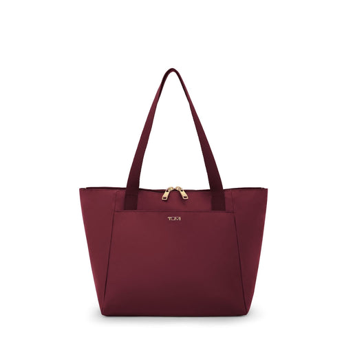Wine TUMI tote bag with gold zipper on a white background