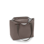 Mink TUMI handbag with a visible brand logo on a white background