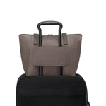 Mink TUMI tote bag on top of a black suitcase on a white background