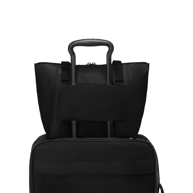 Two black TUMI bags stacked on a white background