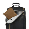 Black TUMI suitcase with a copper pouch and gold zipper on a white background