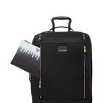 Black TUMI suitcase with gold zippers and a matching pouch on a white background