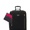 Black TUMI suitcase with gold accents and a pink and black pouch on a white background