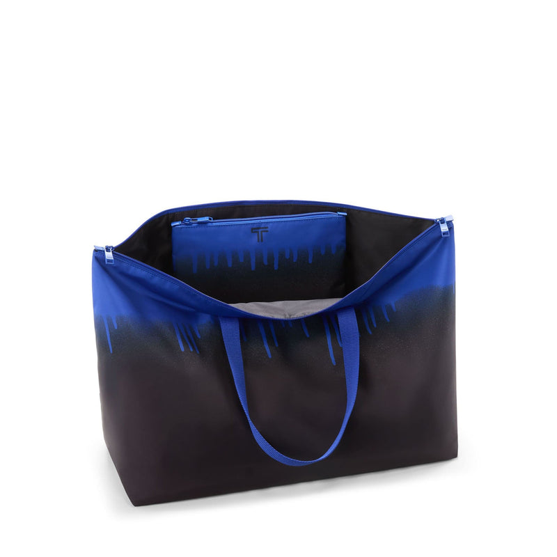 Black and blue TUMI tote bag with gradient effect on a white background