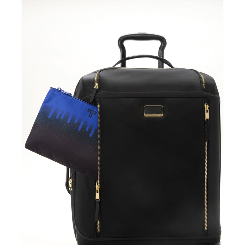 Black TUMI suitcase with gold accents and a blue pouch on a white background