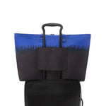 Blue and black TUMI tote bag with a handle on a white background