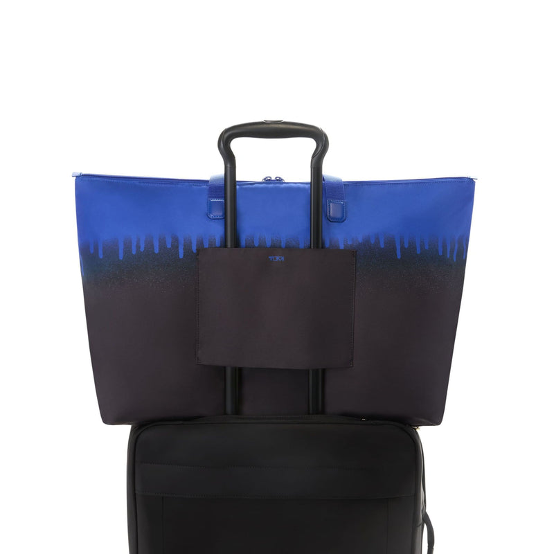 Blue and black TUMI tote bag with a handle on a white background