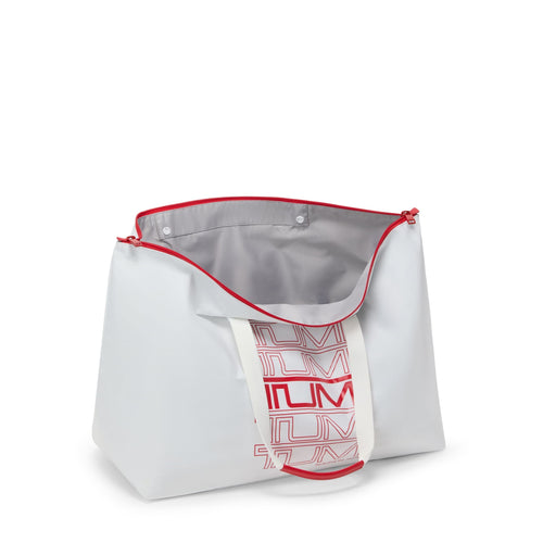 White TUMI tote with red zipper and branding on a white background