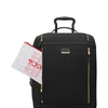 Black suitcase with gold zippers and a TUMI bag on a white background