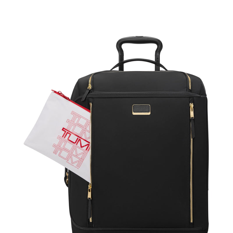 Black suitcase with gold zippers and a TUMI bag on a white background