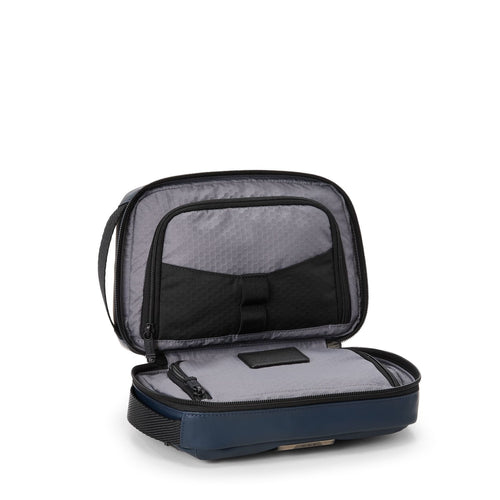 Open TUMI travel toiletry bag on a white background