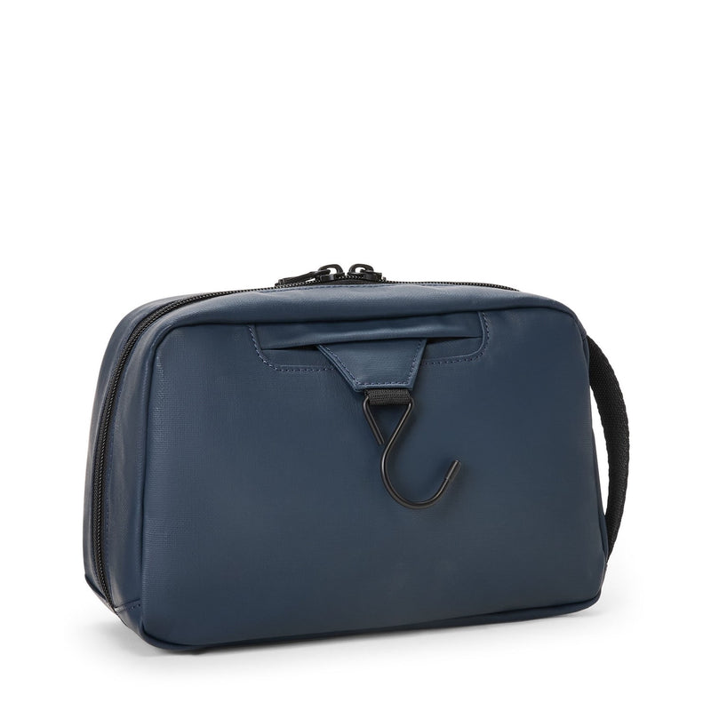 Blue TUMI toiletry bag with a hook on a white background