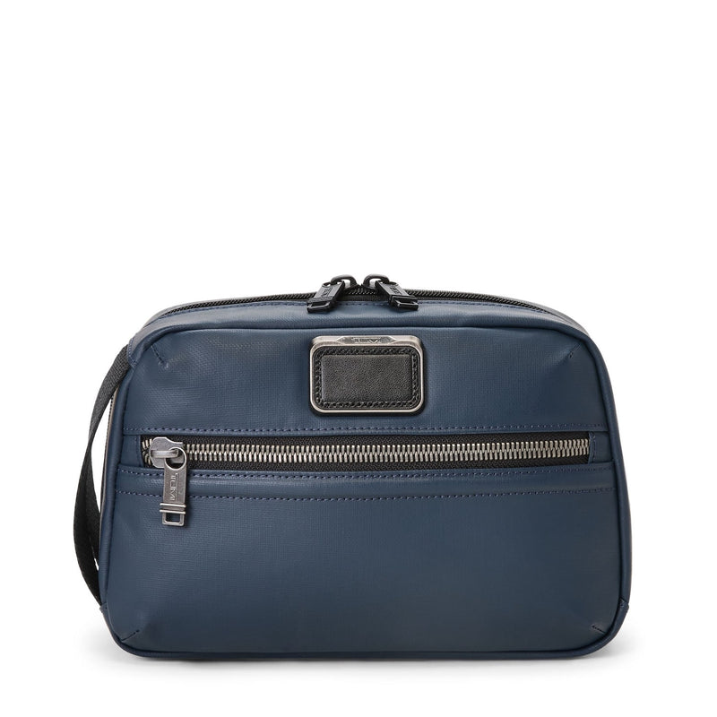 Blue TUMI toiletry bag with a visible brand logo on a white background