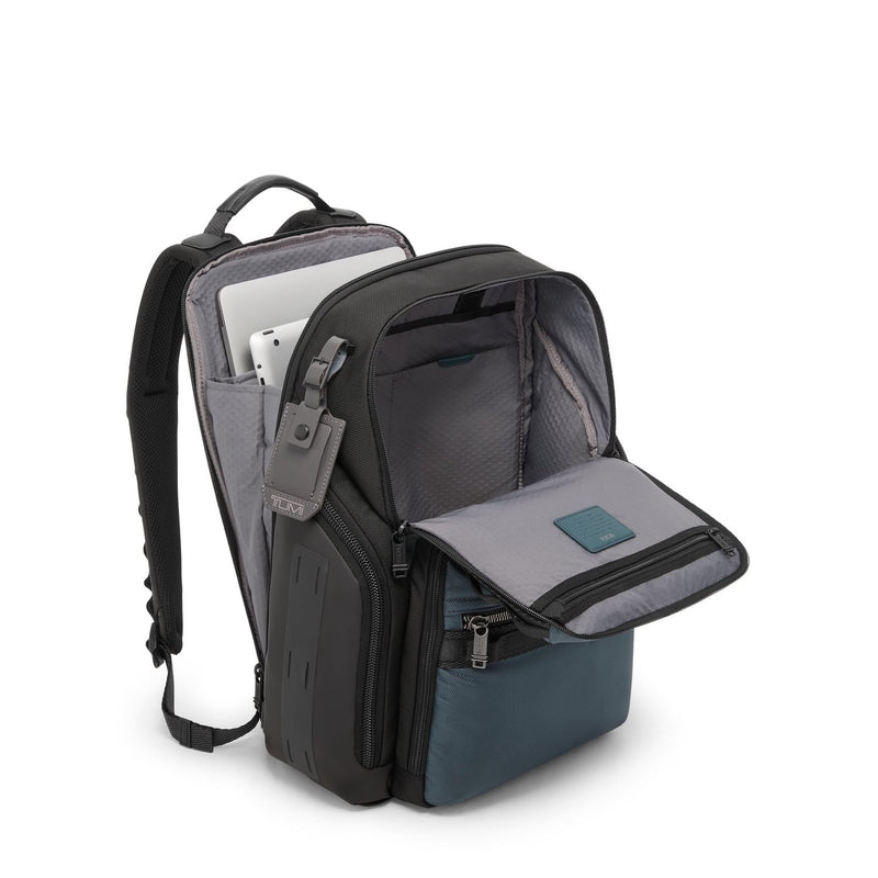 Blue and black TUMI backpack with compartments on a white background