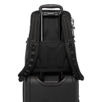 Black TUMI backpack on top of a black suitcase with visible brand logo.