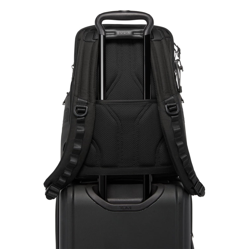 Black TUMI backpack on top of a black suitcase with visible brand logo.