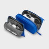 Blue orbitkey carrying case with black interior for electronic devices on a light gray background
