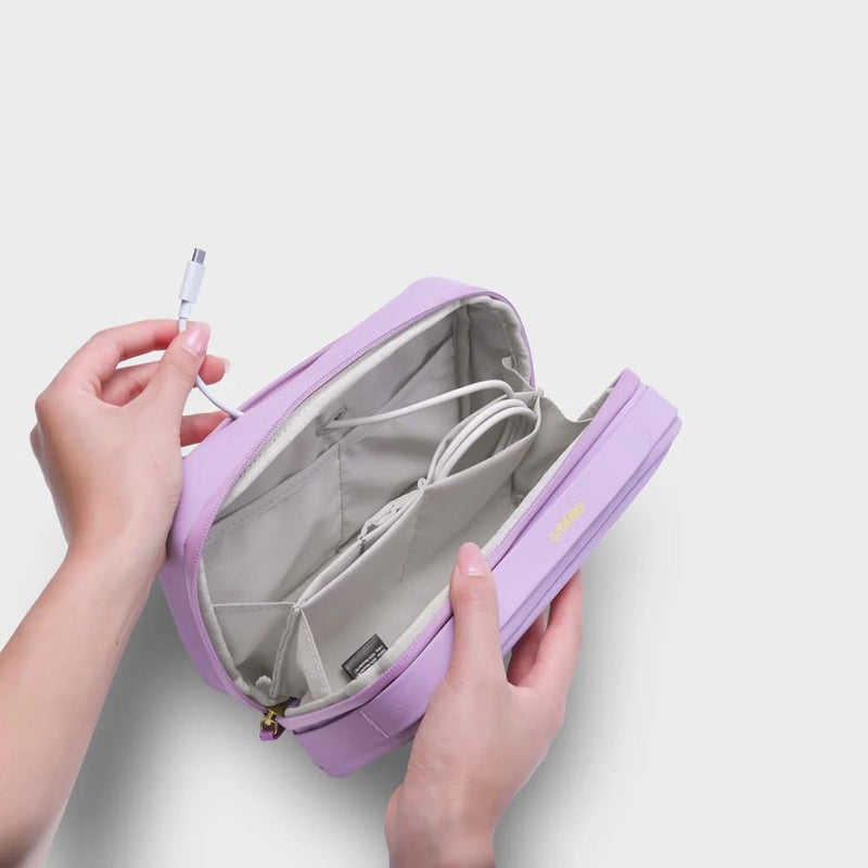 Purple orbitkey travel organizer with a cable being inserted on a light gray background