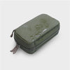 Green orbitkey travel case with visible water droplets on a light gray background