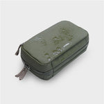 Green orbitkey travel case with visible water droplets on a light gray background