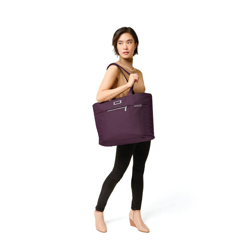 model with plum Briggs & Riley Baseline Traveler Tote