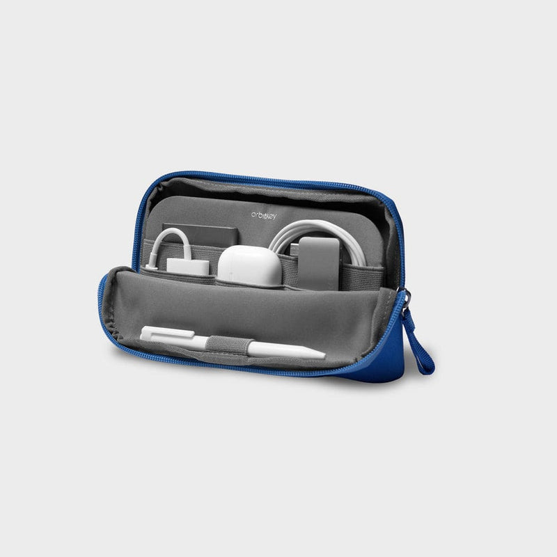 Blue orbitkey travel case with electronic accessories on a light gray background