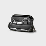 Olive orbitkey travel organizer with various items on a light gray background