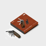 orbitkey key organizer with leather strap on a brown box against a white background