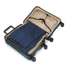 Open Briggs & RIley suitcase with a blue garment inside on a white background