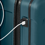 Ocean Briggs & Riley suitcase with a USB cable plugged into a charging port