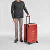 Man Victorinox holding a red suitcase on a light gray background