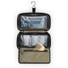 Open Briggs & Riley travel toiletry bag with compartments and a wooden comb on a white background