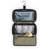 Open Briggs & Riley travel toiletry bag with compartments and a wooden comb on a white background
