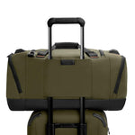 Two green Briggs & Riley bags with black handles and zippers on a white background