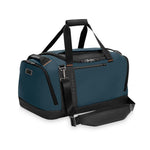 Blue Briggs & Riley duffel bag with black straps on a white background