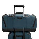 Blue Briggs & Riley duffel bag with black accents on a white background