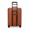 Orange Briggs & Riley suitcase with black accents on white background
