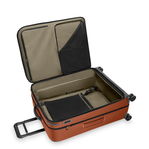 orange Briggs & Riley suitcase on a white background