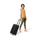 Model with black Briggs & Riley Baseline Global 2-Wheel Carry-on Duffle