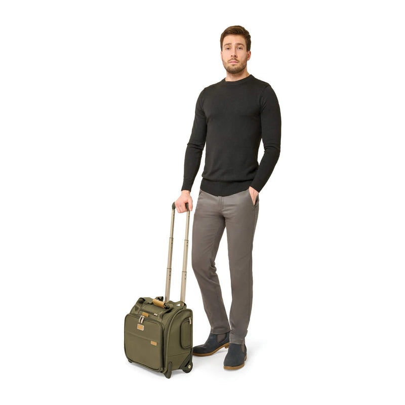 Model with olive Briggs & Riley Baseline 2-Wheel Cabin Bag
