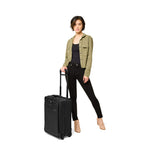 Model with black Briggs & Riley Baseline Essential 2-Wheel Carry-On