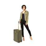 Model with olive Briggs & Riley Baseline Essential 2-Wheel Carry-On