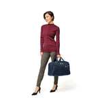 Model with navy Briggs & Riley Baseline Executive Travel Duffle