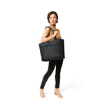 Model with black Briggs & Riley Baseline Traveler Tote