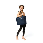 Model with navy Briggs & Riley Baseline Traveler Tote