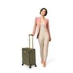 Model with olive Briggs & Riley Baseline Global Carry-On Spinner